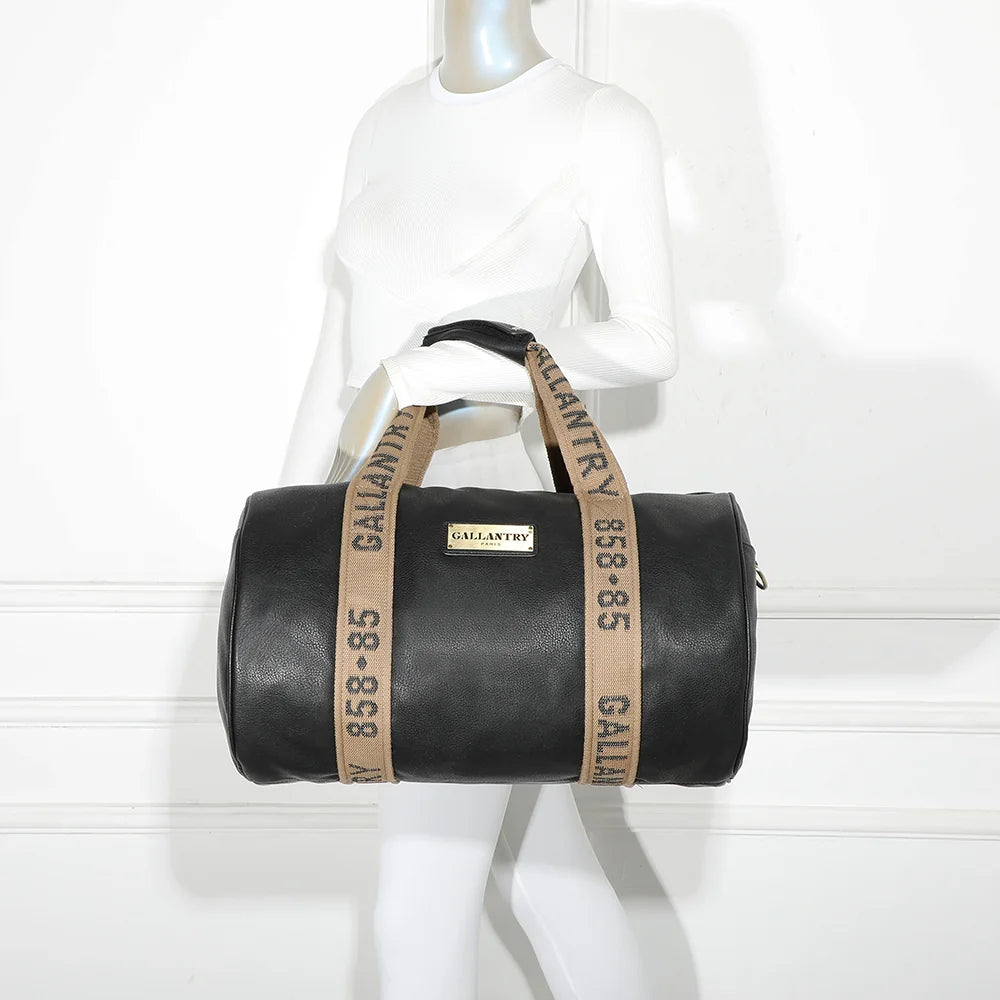 Sac de voyage Polochon noir porté à l’épaule par une femme grâce à sa bandoulière amovible – réf. Z-83049