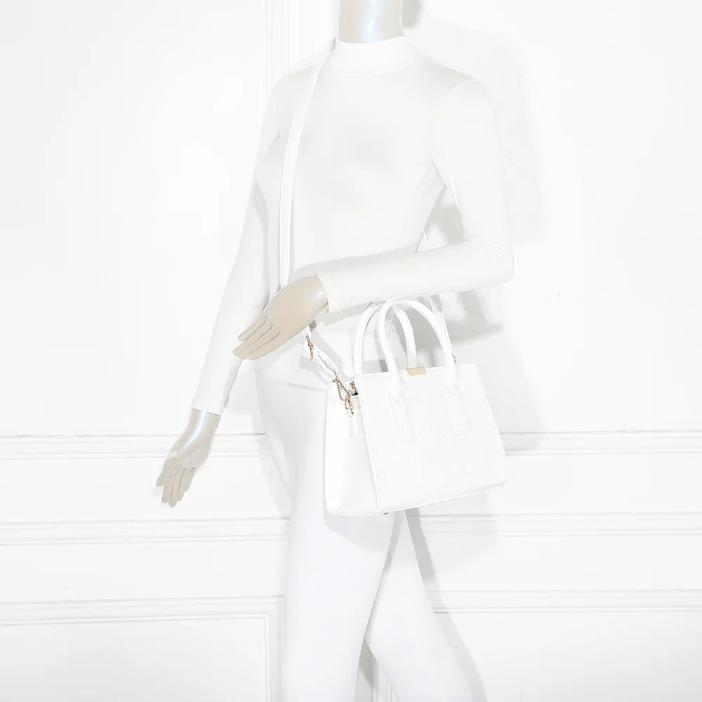 Sac Stella blanc porté par une femme, tenu à la main pour une silhouette chic et structurée – réf. R-1627-2