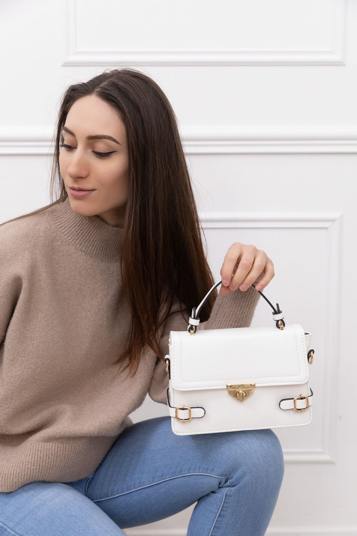 Petit Chic blanc porté par une femme, un petit sac à main structuré avec ses boucles dorées – réf. C-0176-2