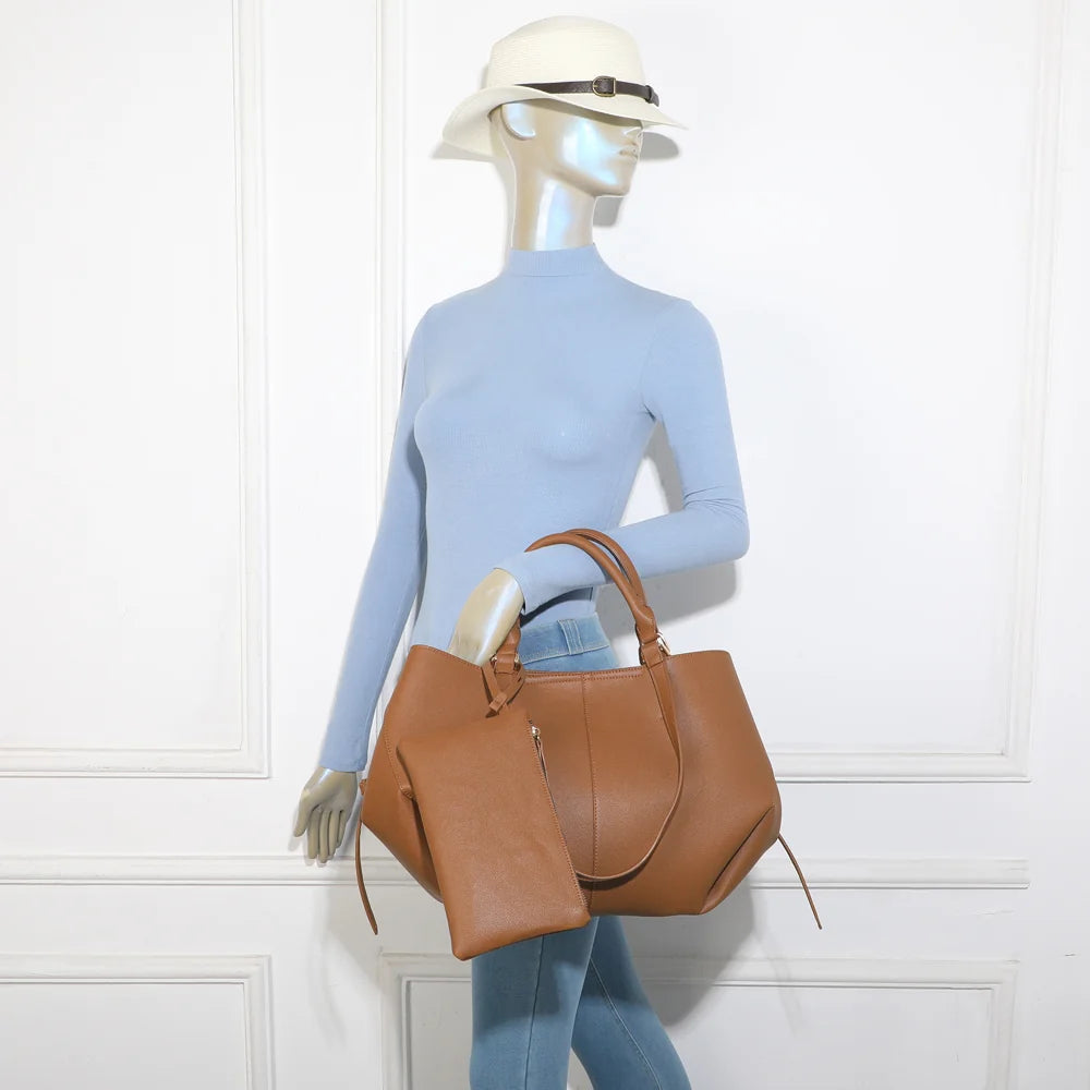 Sac Adriana marron porté par une femme, à la main ou à l’épaule grâce à ses deux paires d’anses – réf. R-1996