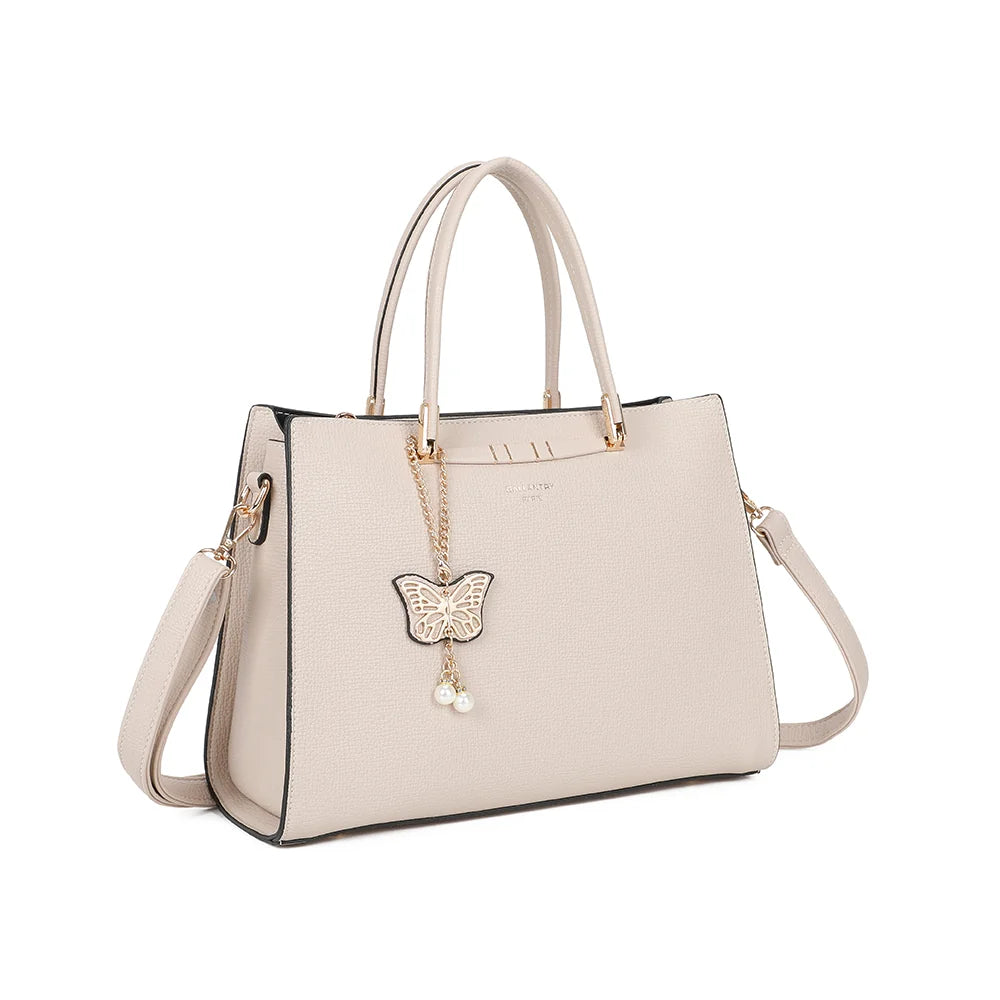 L’Ariane beige de trois quarts : silhouette structurée, pendentif papillon doré et bandoulière amovible – réf. R-1973