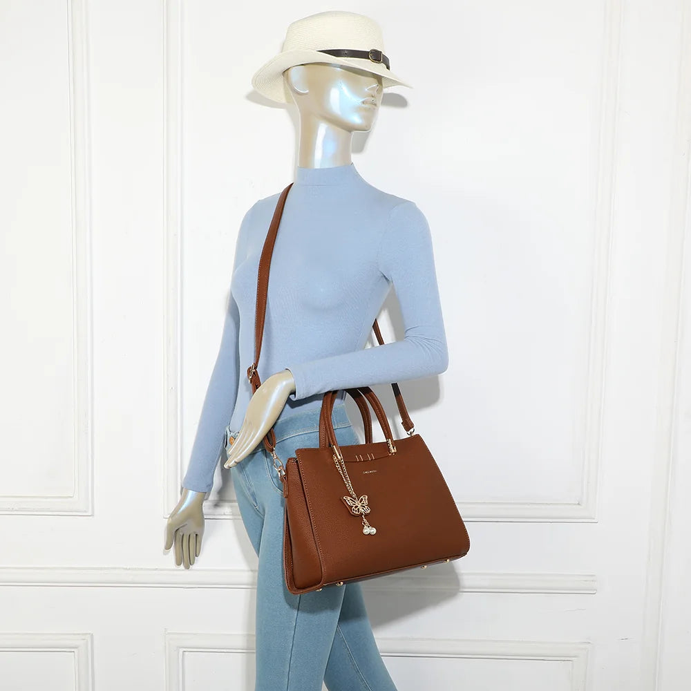 Sac à main Ariane marron foncé porté par une femme, à la main ou à l’épaule avec sa bandoulière amovible – réf. R-1973