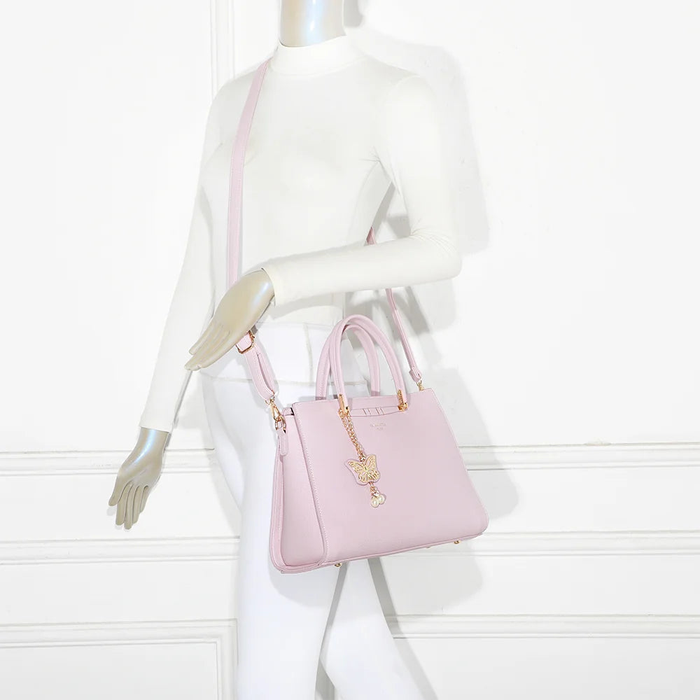 Sac à main Ariane rose porté par une femme, à la main ou à l’épaule avec sa bandoulière amovible – réf. R-1973