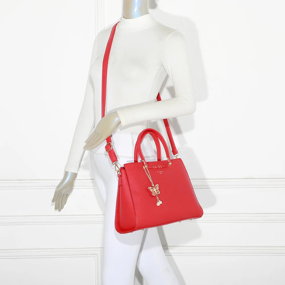 Sac à main Ariane rouge porté par une femme, à la main ou à l’épaule avec sa bandoulière amovible – réf. R-1973
