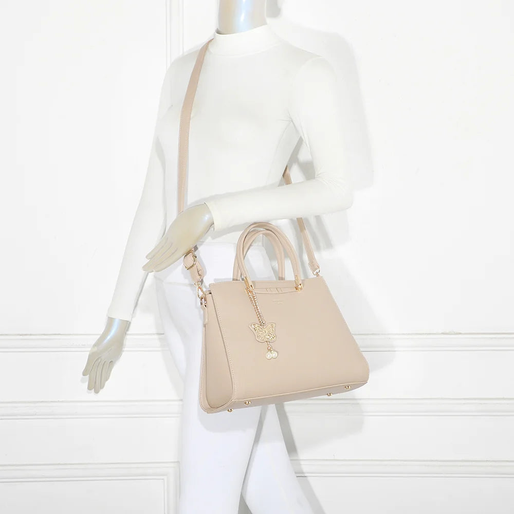 Sac à main Ariane taupe clair porté par une femme, à la main ou à l’épaule avec sa bandoulière amovible – réf. R-1973