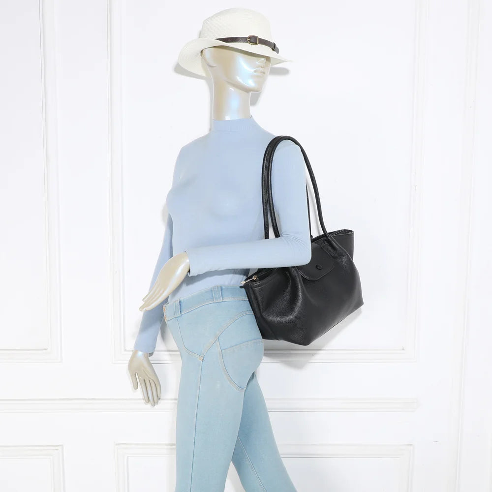 Sac Aura Soft noir porté à l’épaule par une femme, grâce à ses longues anses rondes de 30 cm – réf. R-2033