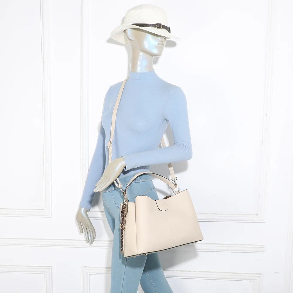 Sac Aurélia beige porté par une femme, à la main ou à l’épaule avec sa bandoulière réglable – réf. DQ-8711