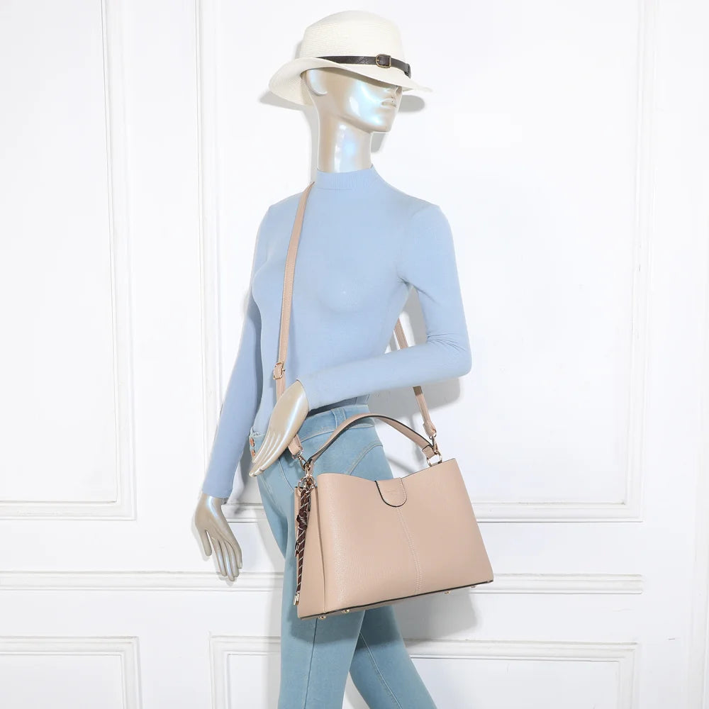Sac Aurélia taupe porté par une femme, à la main ou à l’épaule avec sa bandoulière réglable – réf. DQ-8711
