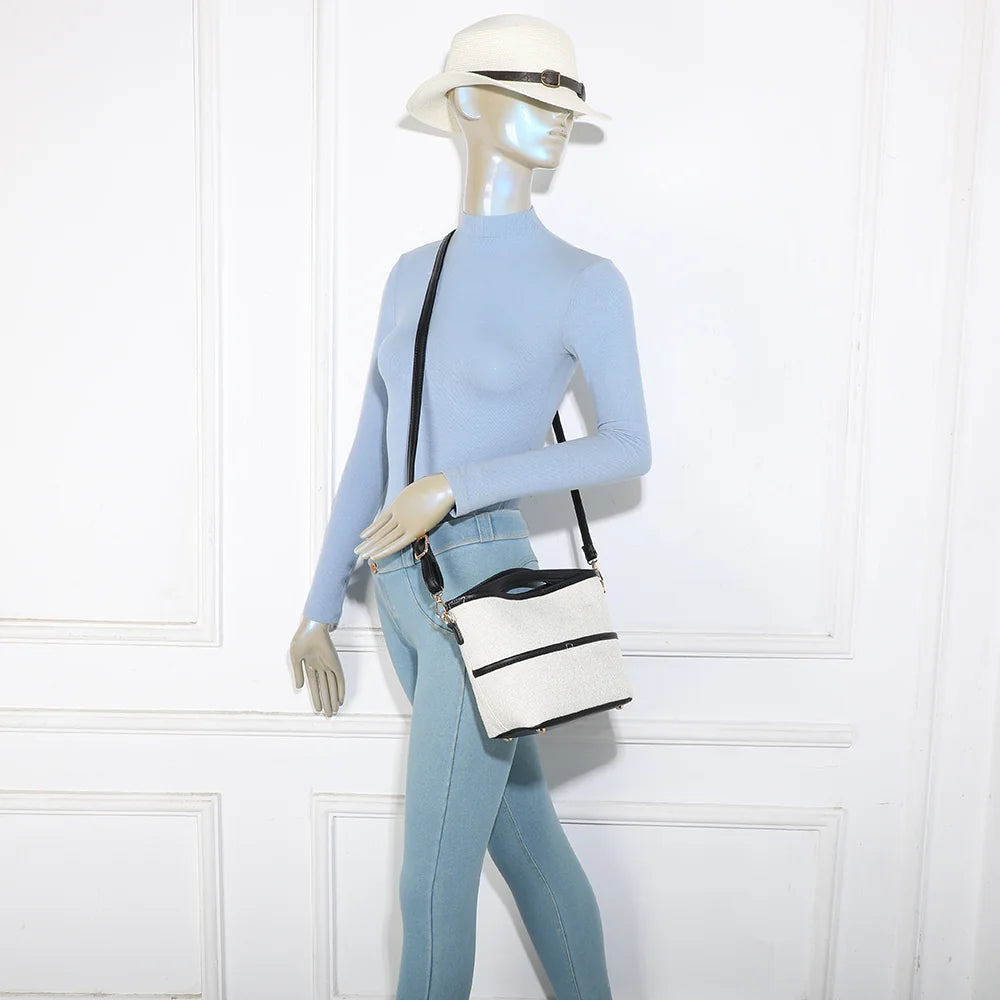 Sac Ava Épure beige/noir porté par une femme, à la main ou avec sa bandoulière amovible – réf. R-2026-1