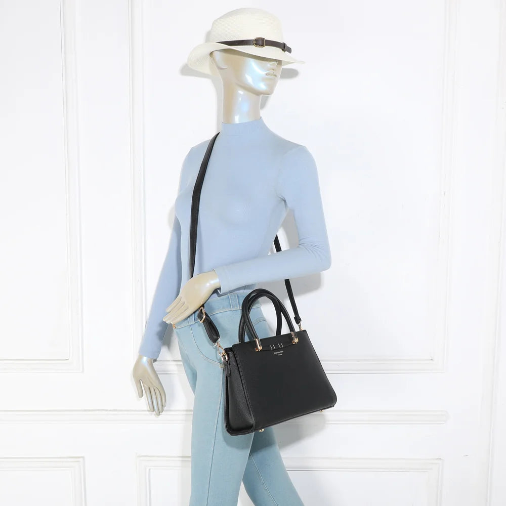 Sac Azure noir porté par une femme, à la main ou à l’épaule avec sa bandoulière amovible – réf. R-1973-S
