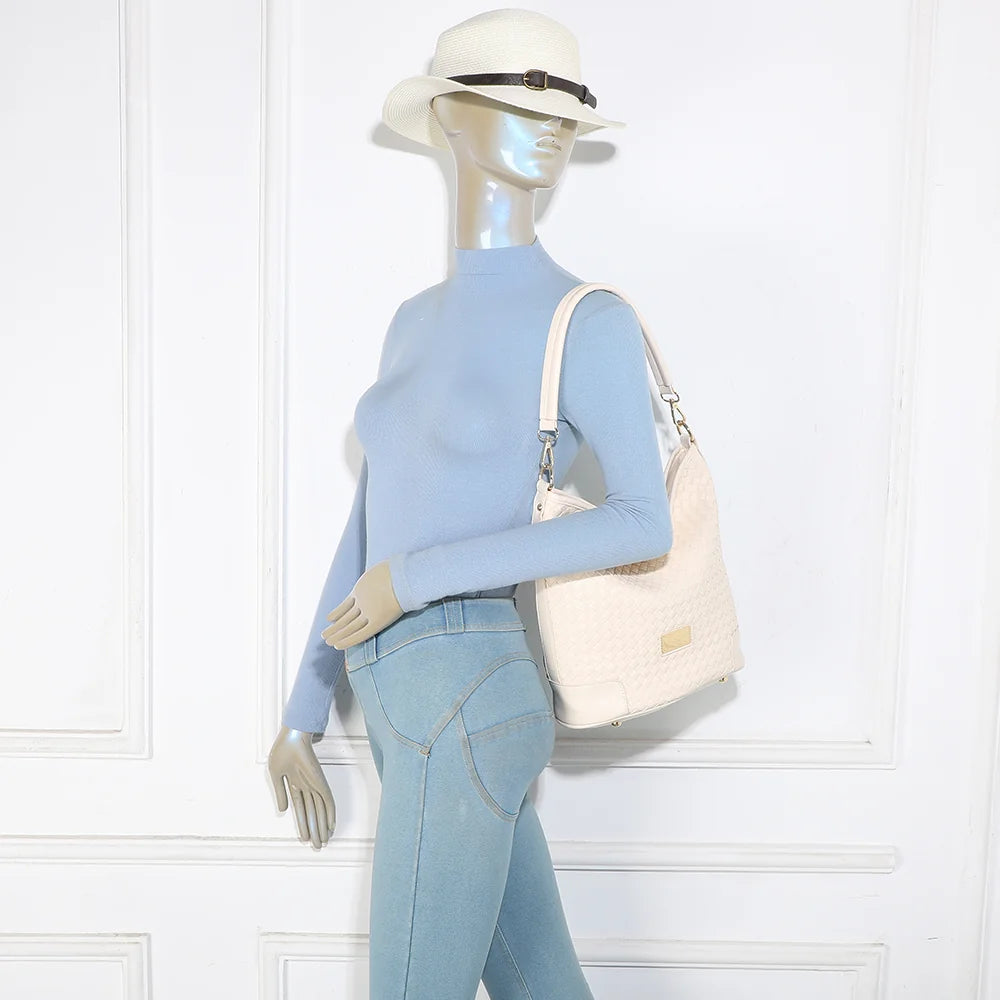 Sac Bellina beige porté par une femme, à l’épaule avec son anse courte – réf. M-9271-10