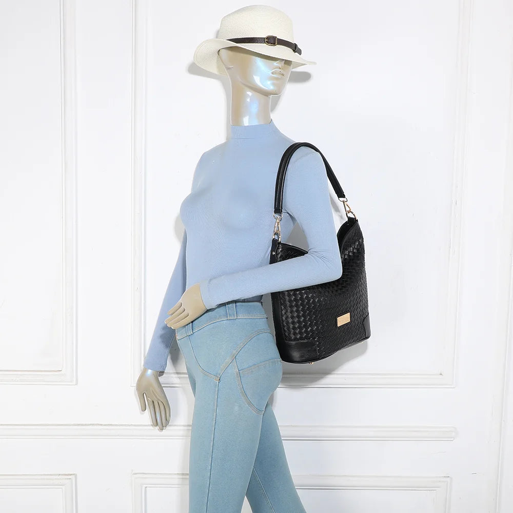 Sac Bellina noir porté par une femme, à l’épaule avec son anse courte – réf. M-9271-10