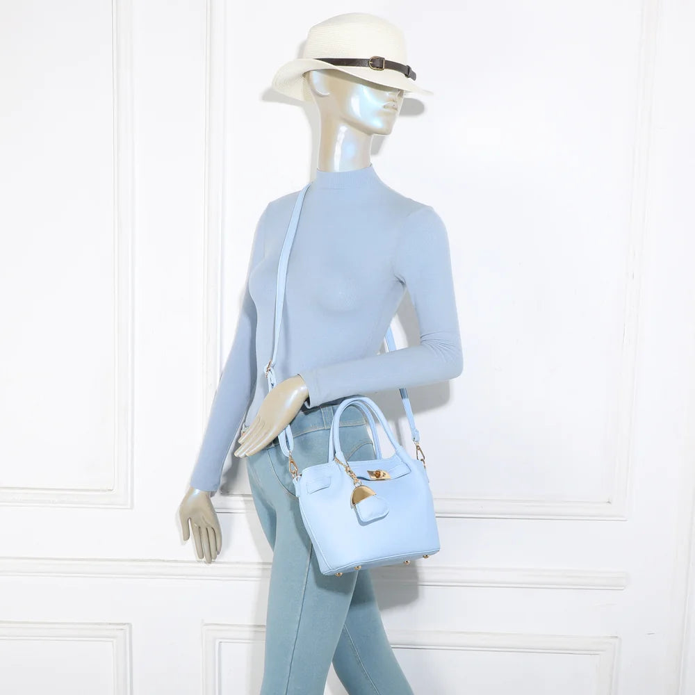 Sac Blossom bleu clair porté par une femme, à la main ou à l’épaule grâce à sa bandoulière amovible – réf. A-9149