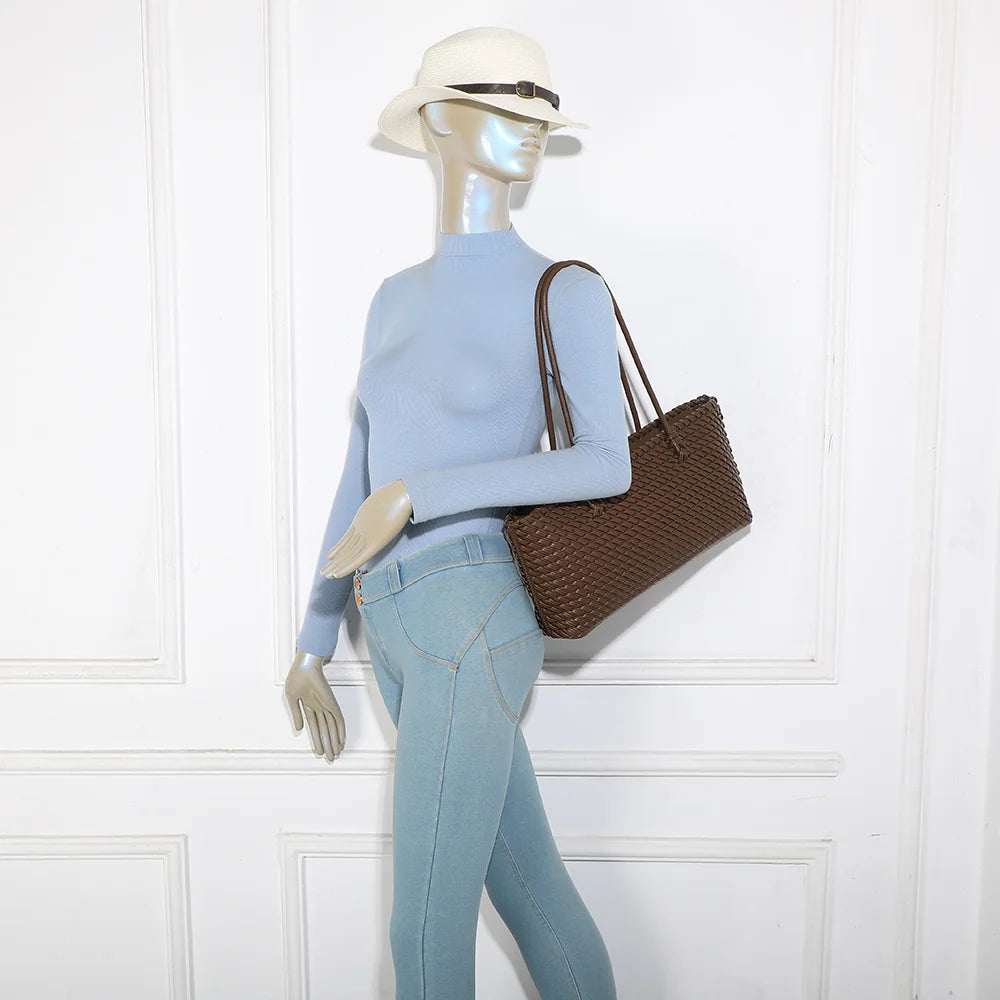 Sac cabas tressé Bréva café porté à l’épaule par une femme, grâce à ses anses longues de 29 cm de hauteur – réf. DG-5822