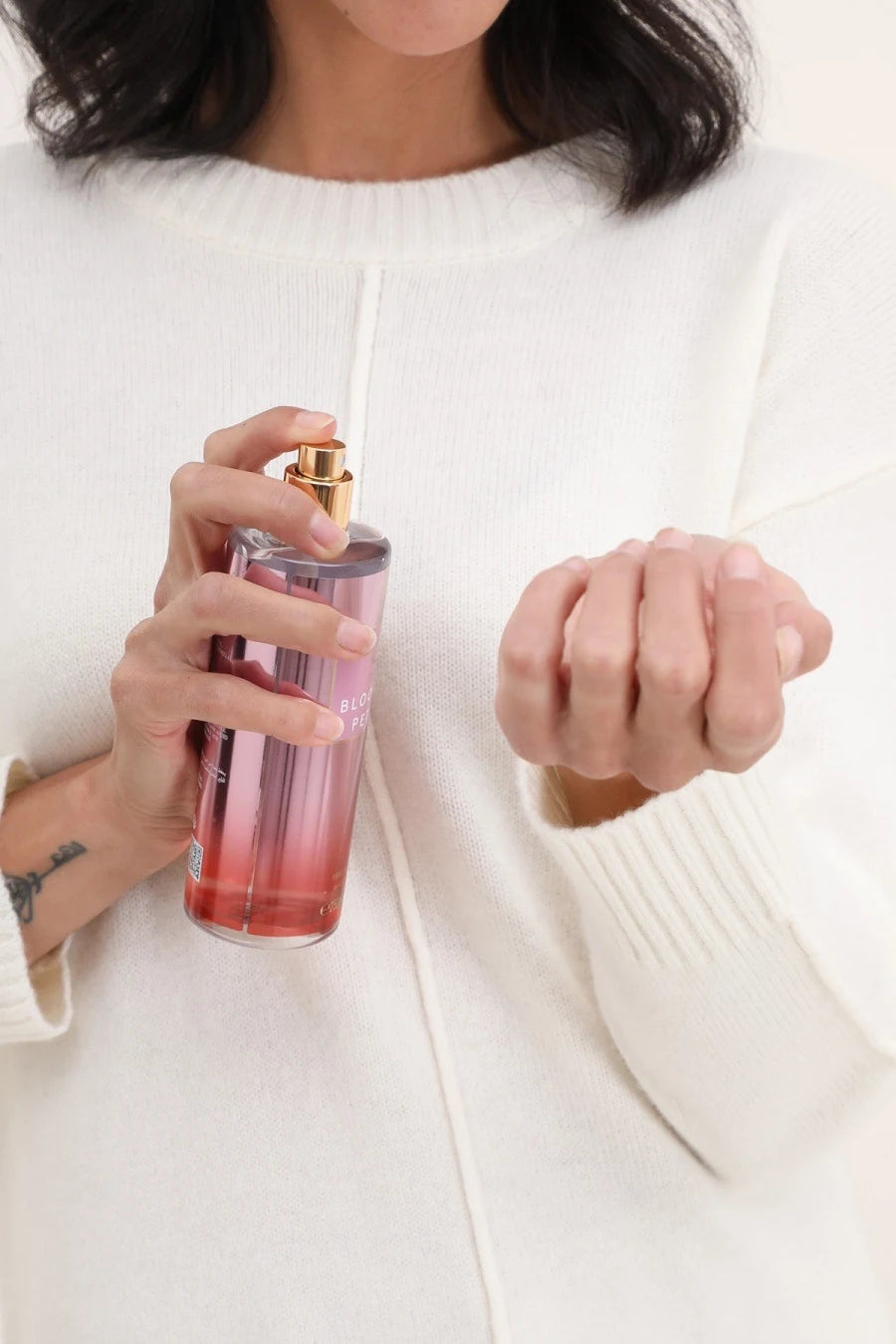 Femme vaporisant la brume parfumée Blooming Petals de Gallantry Paris sur ses cheveux