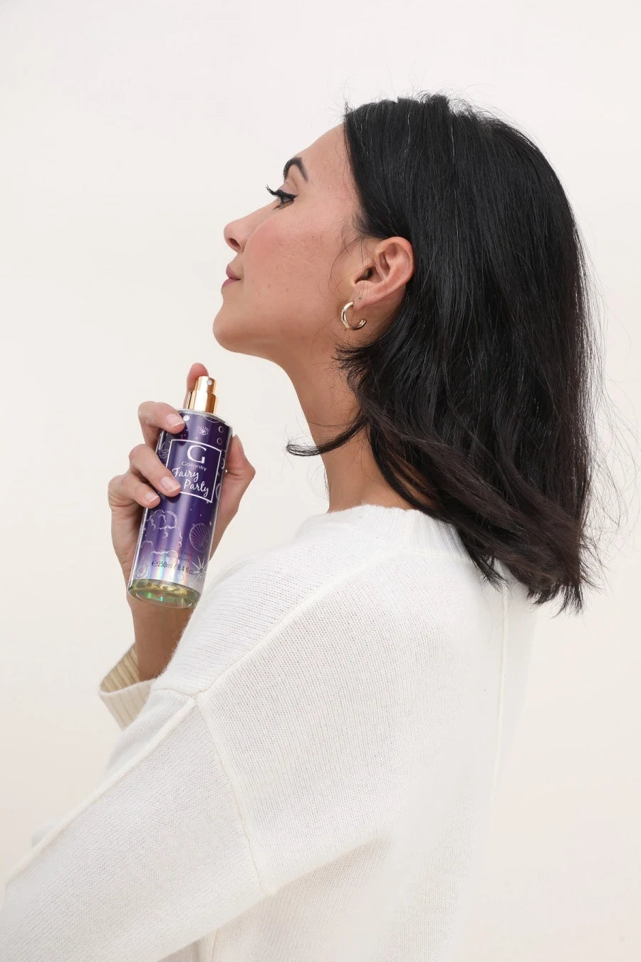 Femme vaporisant la brume parfumée Fairy Party de Gallantry Paris dans ses cheveux