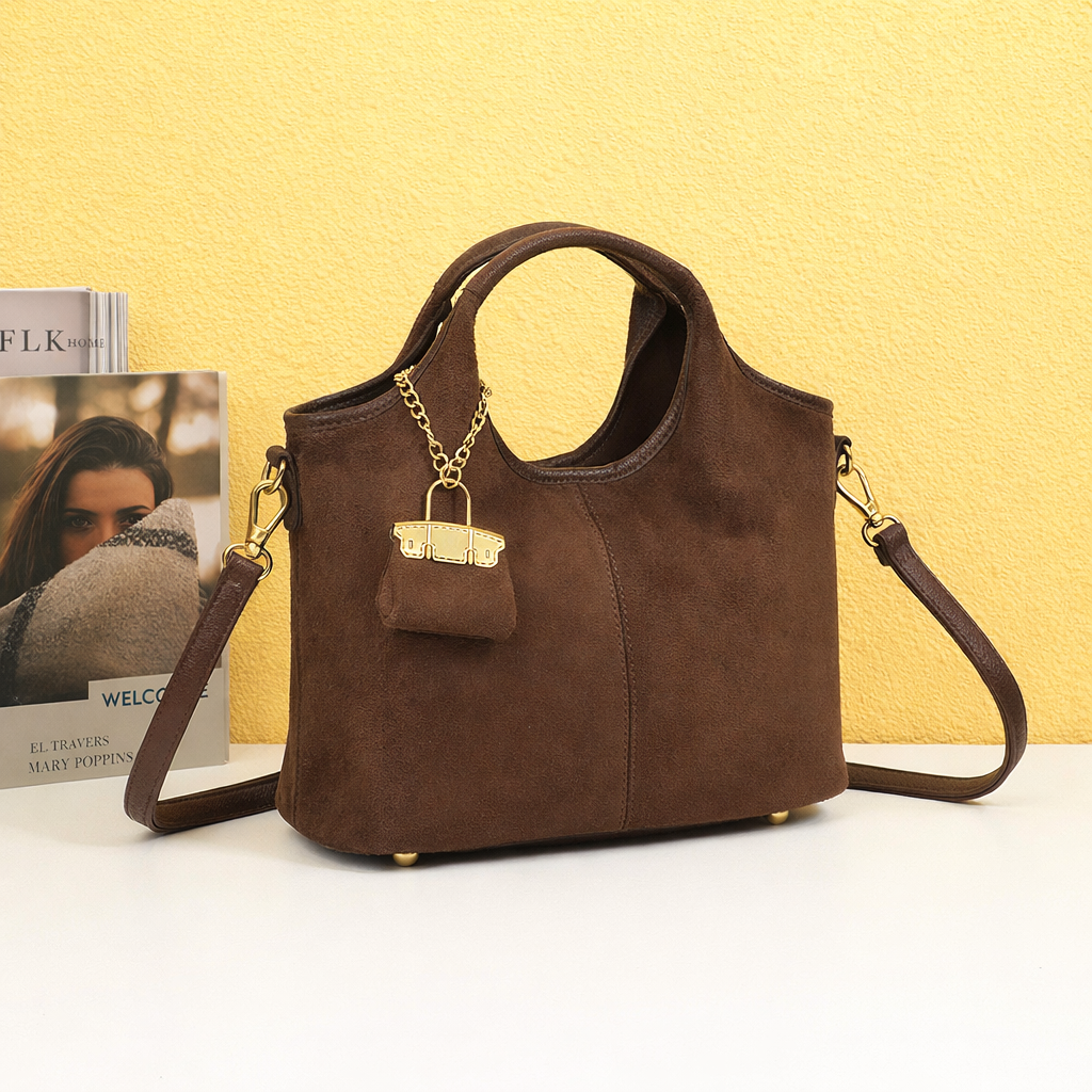 Sac à main Celestia Suédine Coffee et sa pochette assortie dans une mise en scène chaleureuse – visuel d’ambiance créé avec l’IA – Gallantry Paris