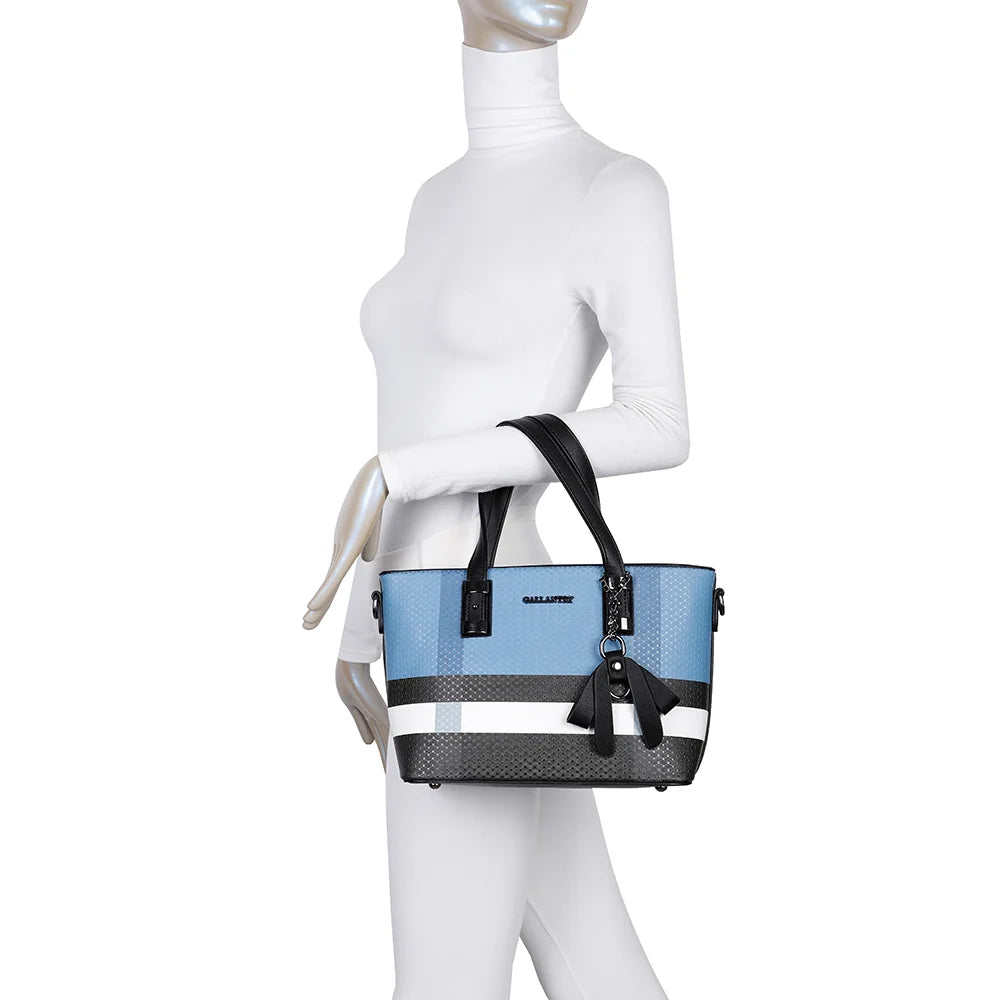 Le Contrast Pop bleu/noir porté par une femme, à la main par ses anses ou à l’épaule avec sa bandoulière – réf. M-9329-17