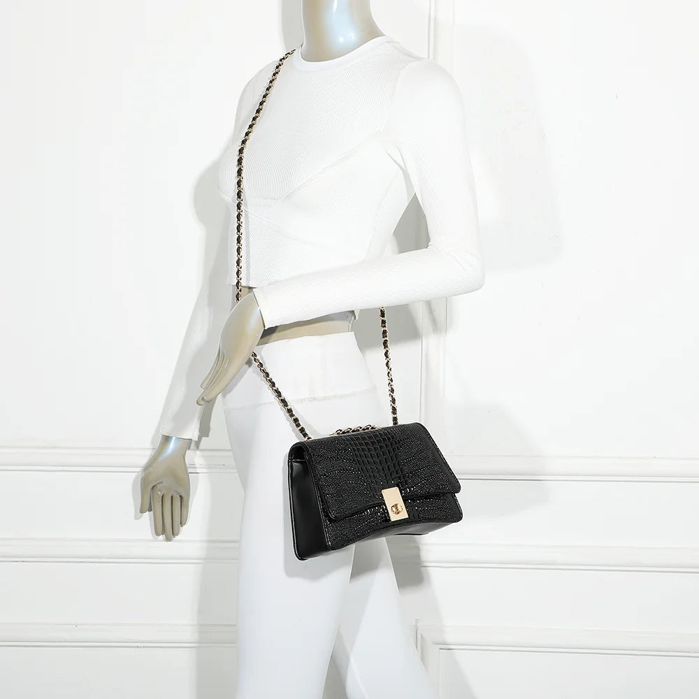 Sac Corail noir porté par une femme avec sa chaîne dorée, à l’épaule ou en bandoulière – réf. R-6661
