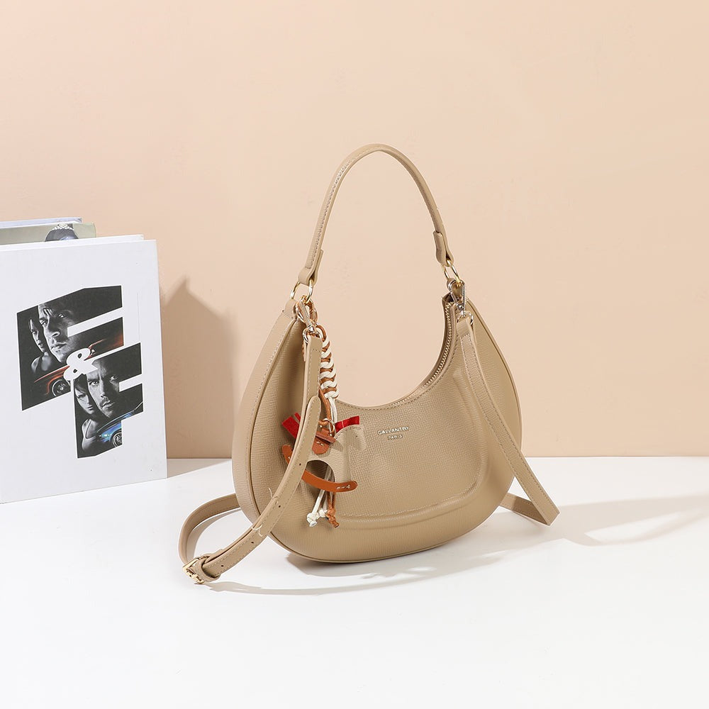 Sac à main demi-lune Dolce Luna taupe avec bijou cheval tressé, mis en scène dans un décor – visuel d’ambiance créé avec l’IA – Gallantry Paris