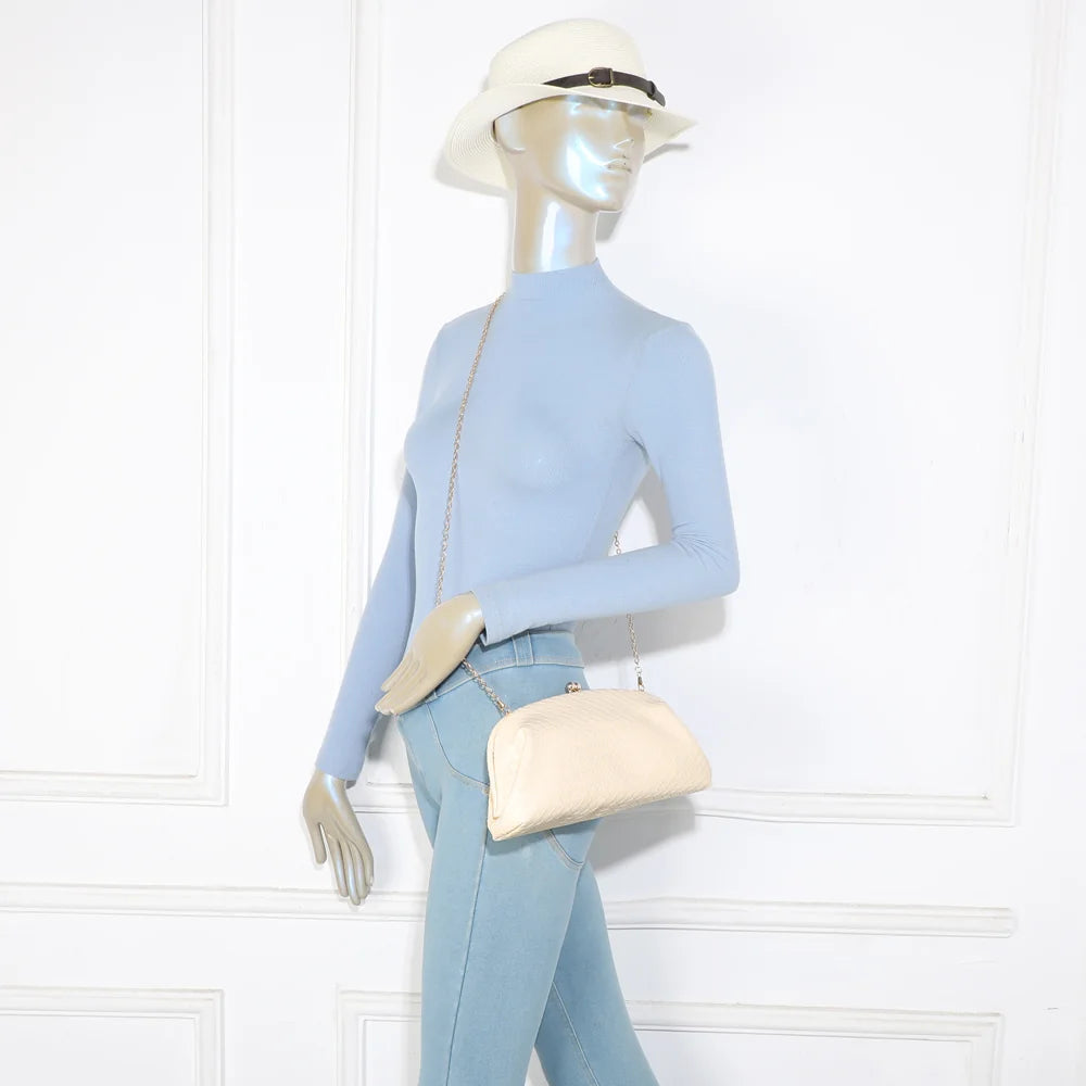 Pochette Doria beige portée par une femme, en bandoulière grâce à sa chaîne fine amovible – réf. LH-71005