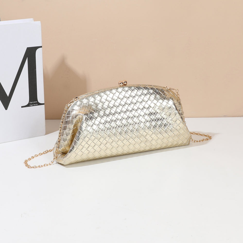 Pochette tressée Doria or mise en scène dans un décor, fermoir bijou et chaîne fine – visuel d’ambiance créé avec l’IA – Gallantry Paris