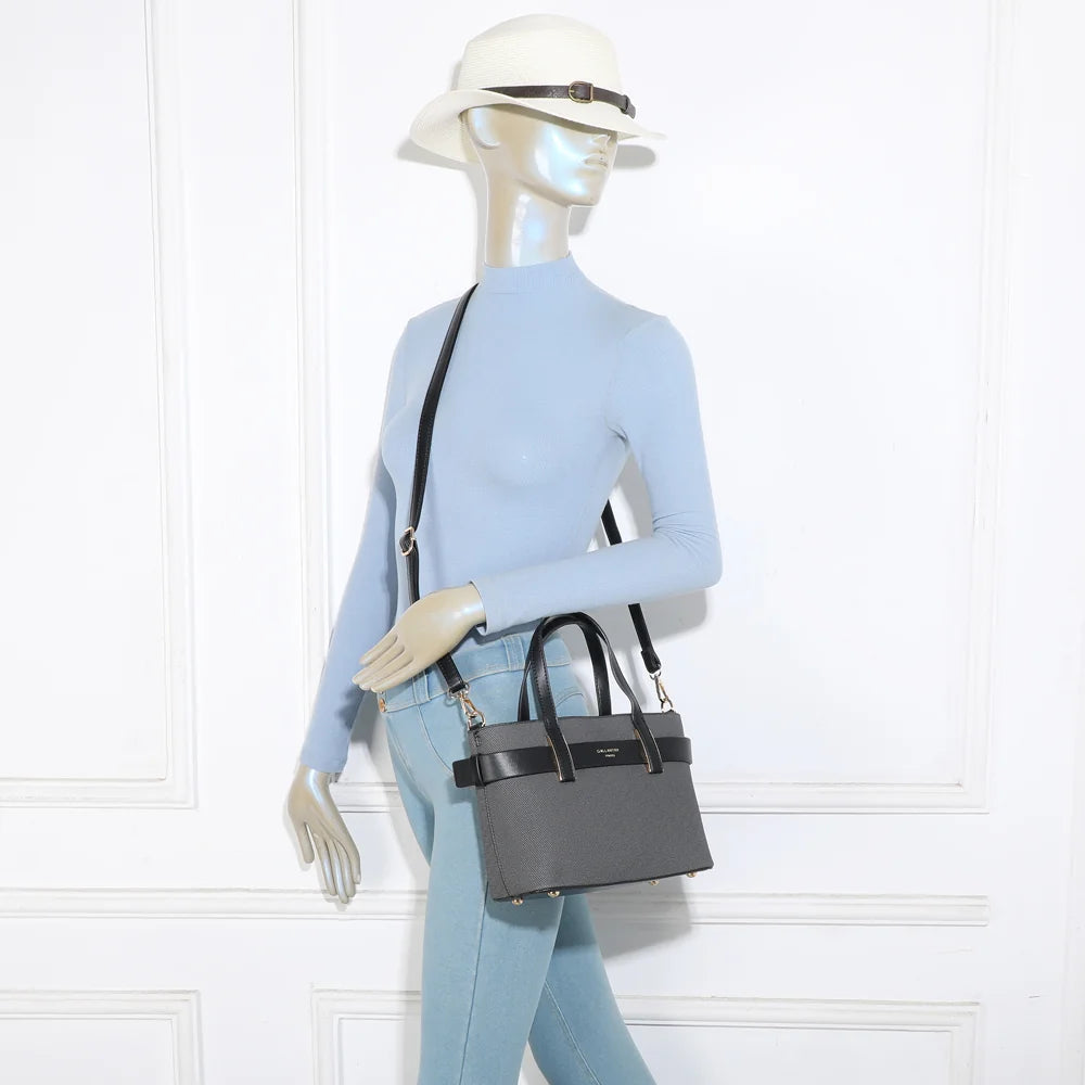 Sac Eden noir porté par une femme, à la main ou en bandoulière grâce à sa sangle réglable – réf. DQ-8714-1