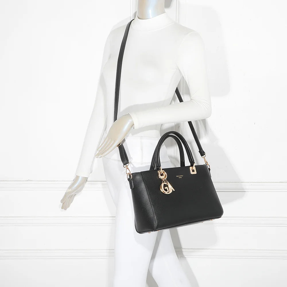 Sac à main femme Élancia noir porté à la main, bijou GA doré en façade, allure chic – réf. DQ-8696