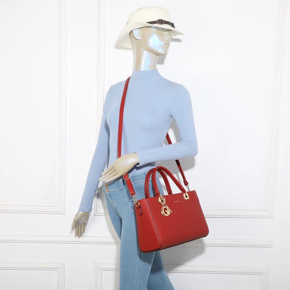 Sac à main femme Élancia rouge foncé porté à la main, bijou GA doré en façade, allure chic – réf. DQ-8696