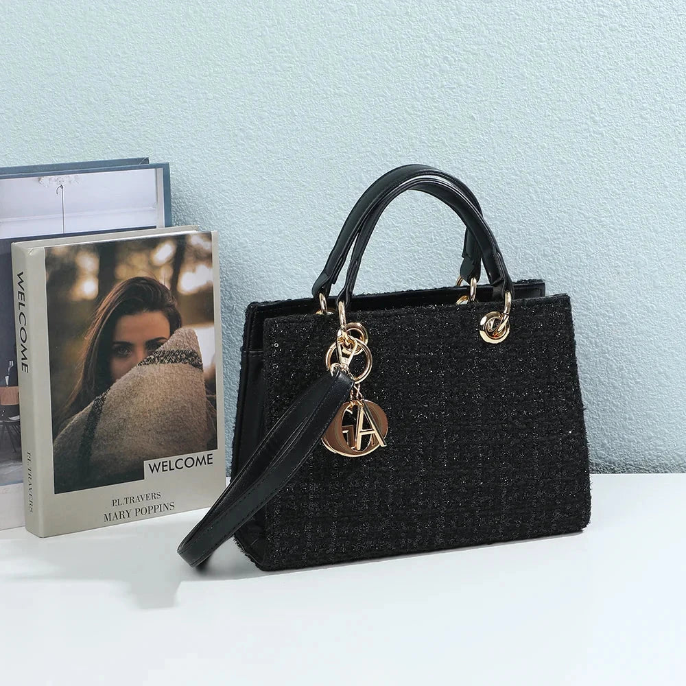 Sac à main femme Élia noir effet tweed posé devant des livres – visuel d'ambiance créé avec l'IA – Gallantry Paris