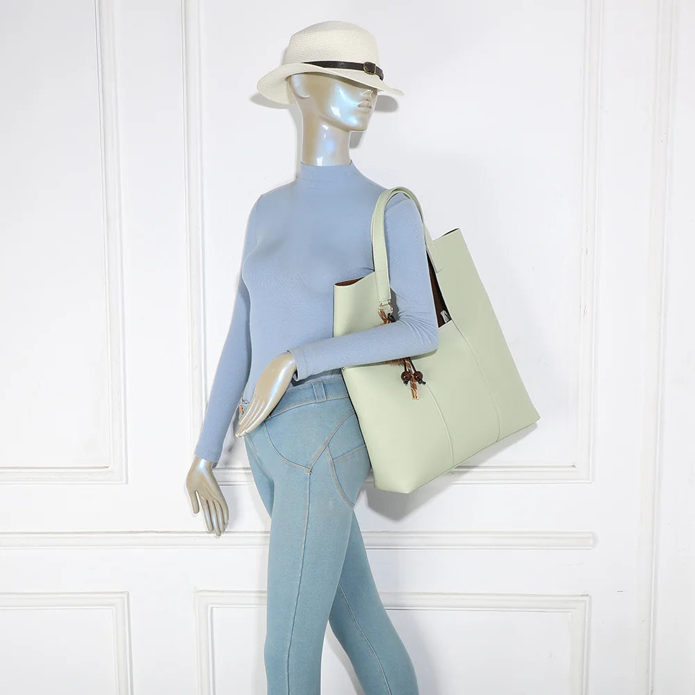 Sac cabas Erythéa vert clair porté à l’épaule par une femme grâce à ses anses de 31 cm – réf. R-2027