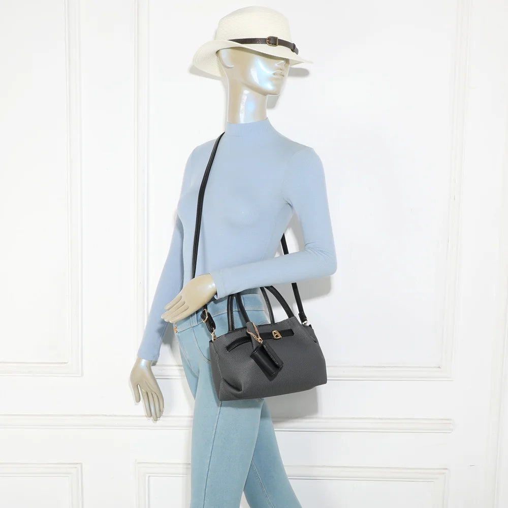 Sac Esmée noir porté par une femme, à la main ou avec sa bandoulière amovible – réf. A-9156-1