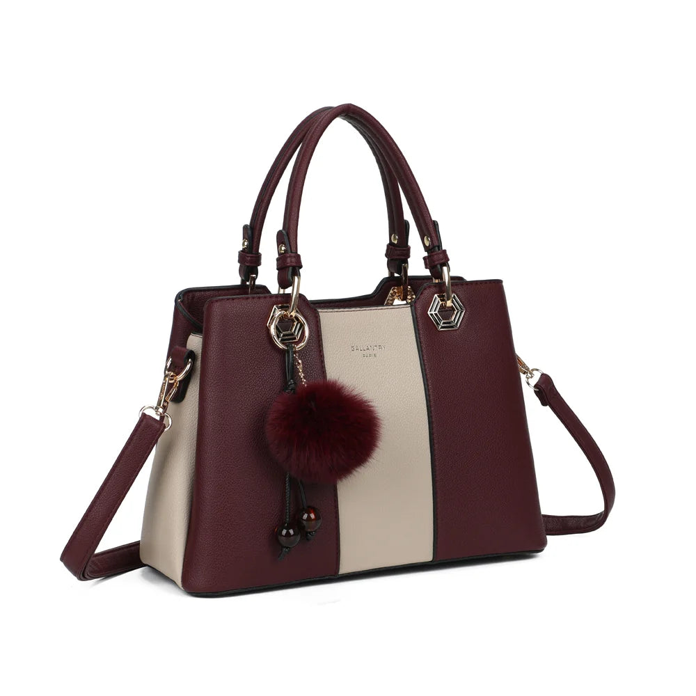 Fiora Pop bordeaux vu de trois quarts : silhouette structurée, quincaillerie dorée hexagonale et pompon – réf. M-9354-3