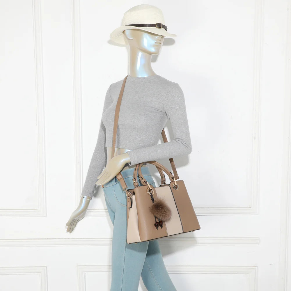 Fiora Pop taupe foncé porté par une femme, à la main ou à l’épaule grâce à sa bandoulière ajustable – réf. M-9354-3