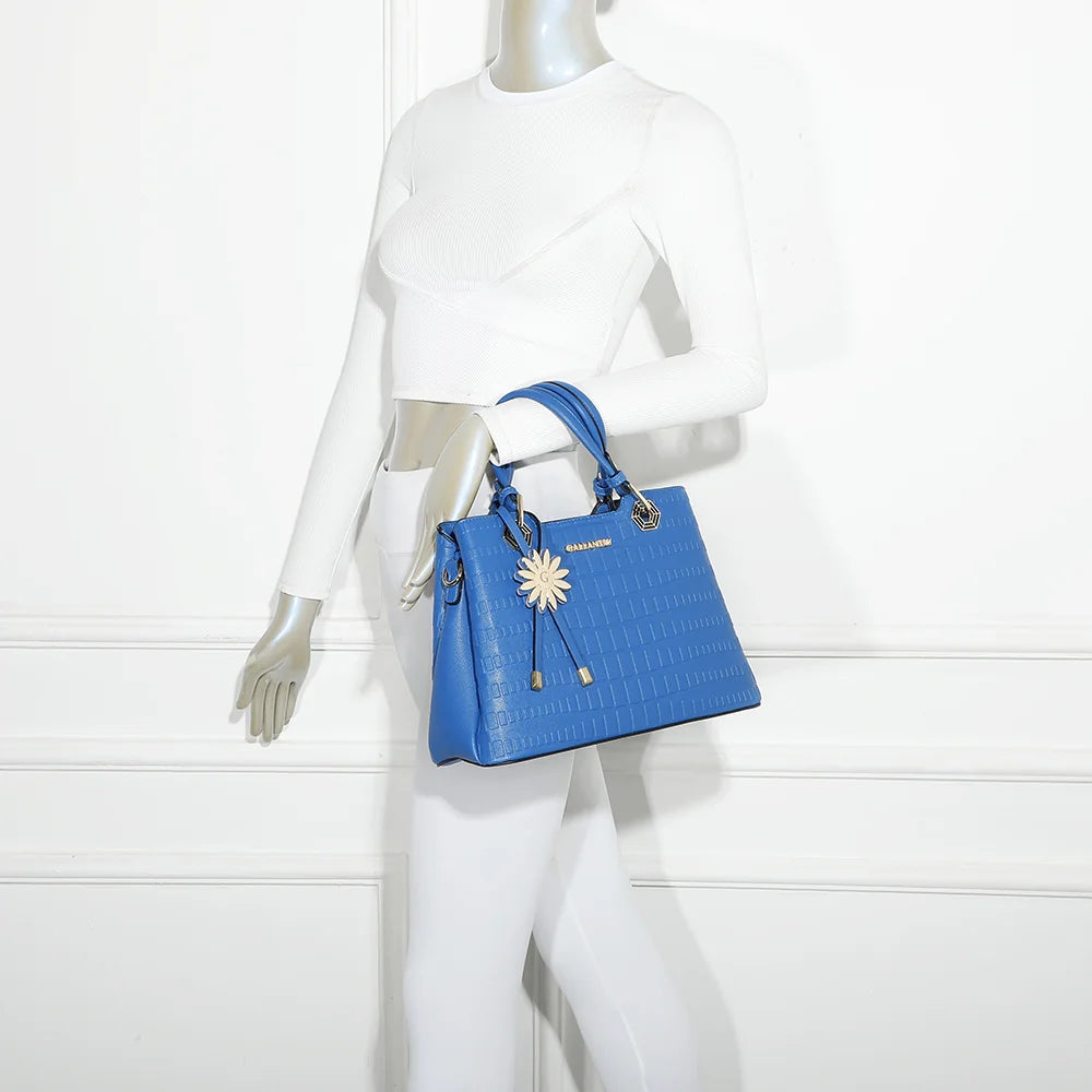 Sac à main femme Fiora bleu porté, charm fleur doré et motif embossé façon croco – réf. M-9354
