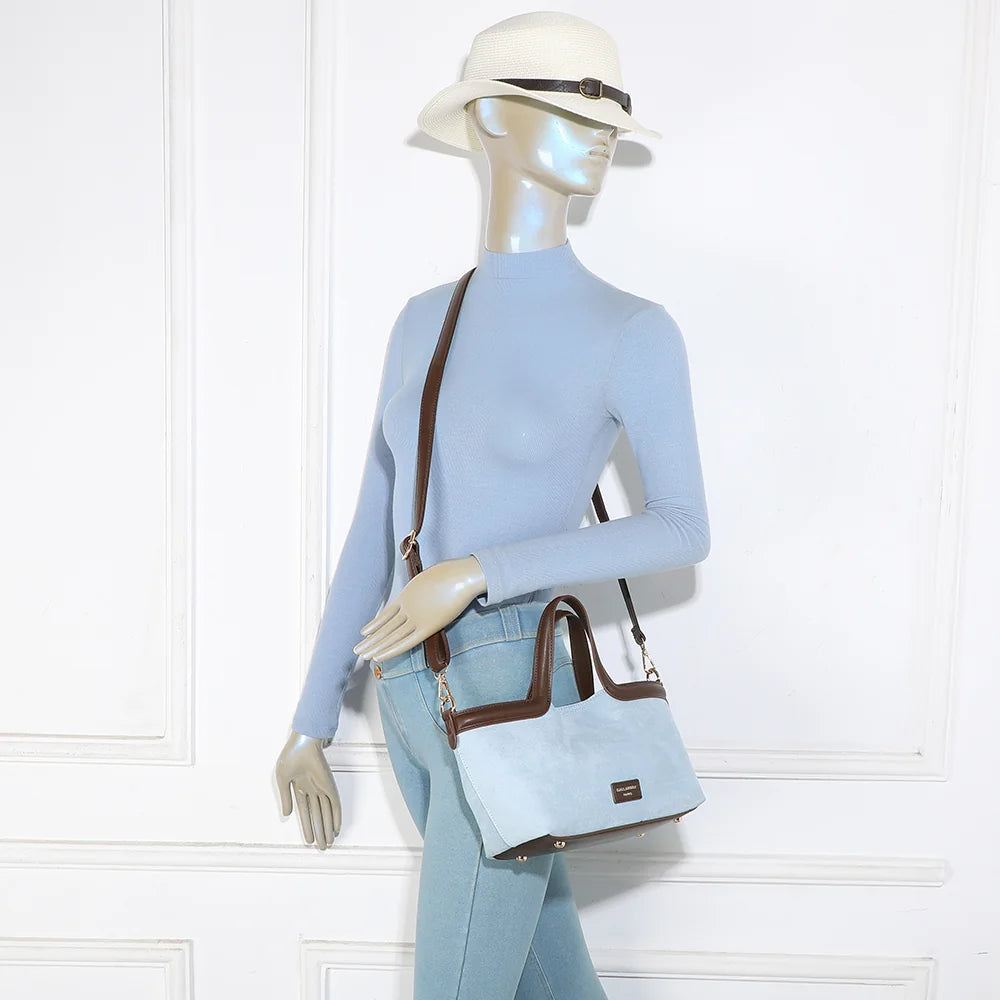 Sac Horizon Chic bleu clair porté par une femme, à la main ou avec sa bandoulière – réf. R-2038-1