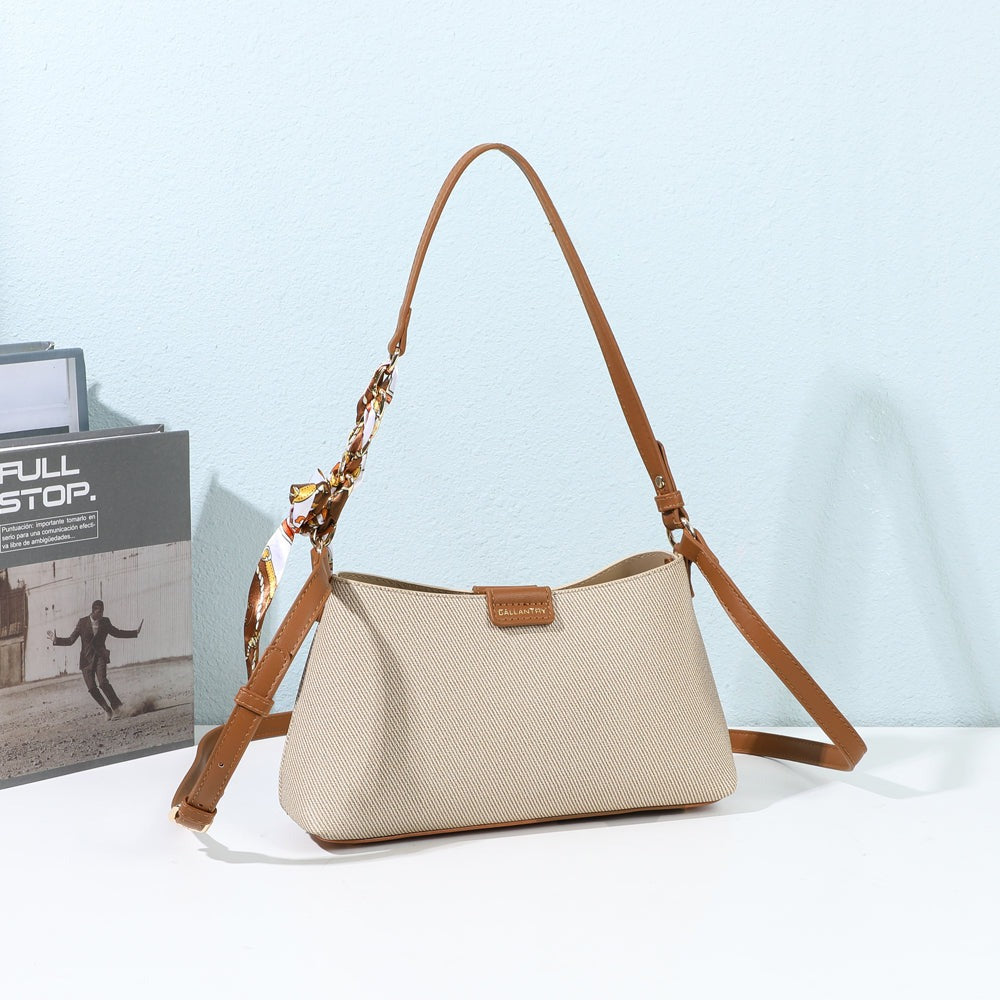 Sac à main Kael taupe et marron posé dans un décor, foulard imprimé et chaîne dorée sur l’anse – visuel d’ambiance créé avec l’IA – Gallantry Paris
