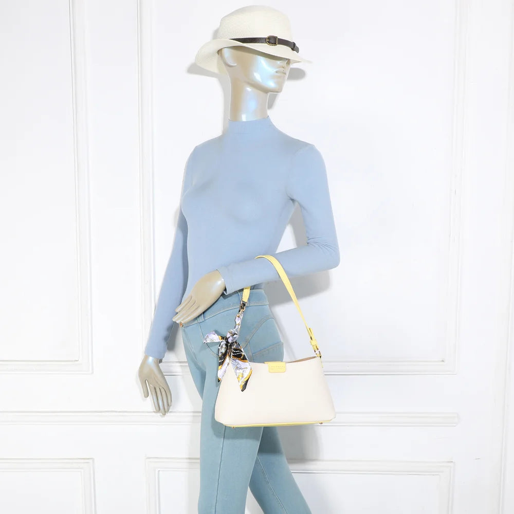 Sac Kael jaune porté par une femme, à l’épaule, foulard noué sur l’anse – réf. A-9155