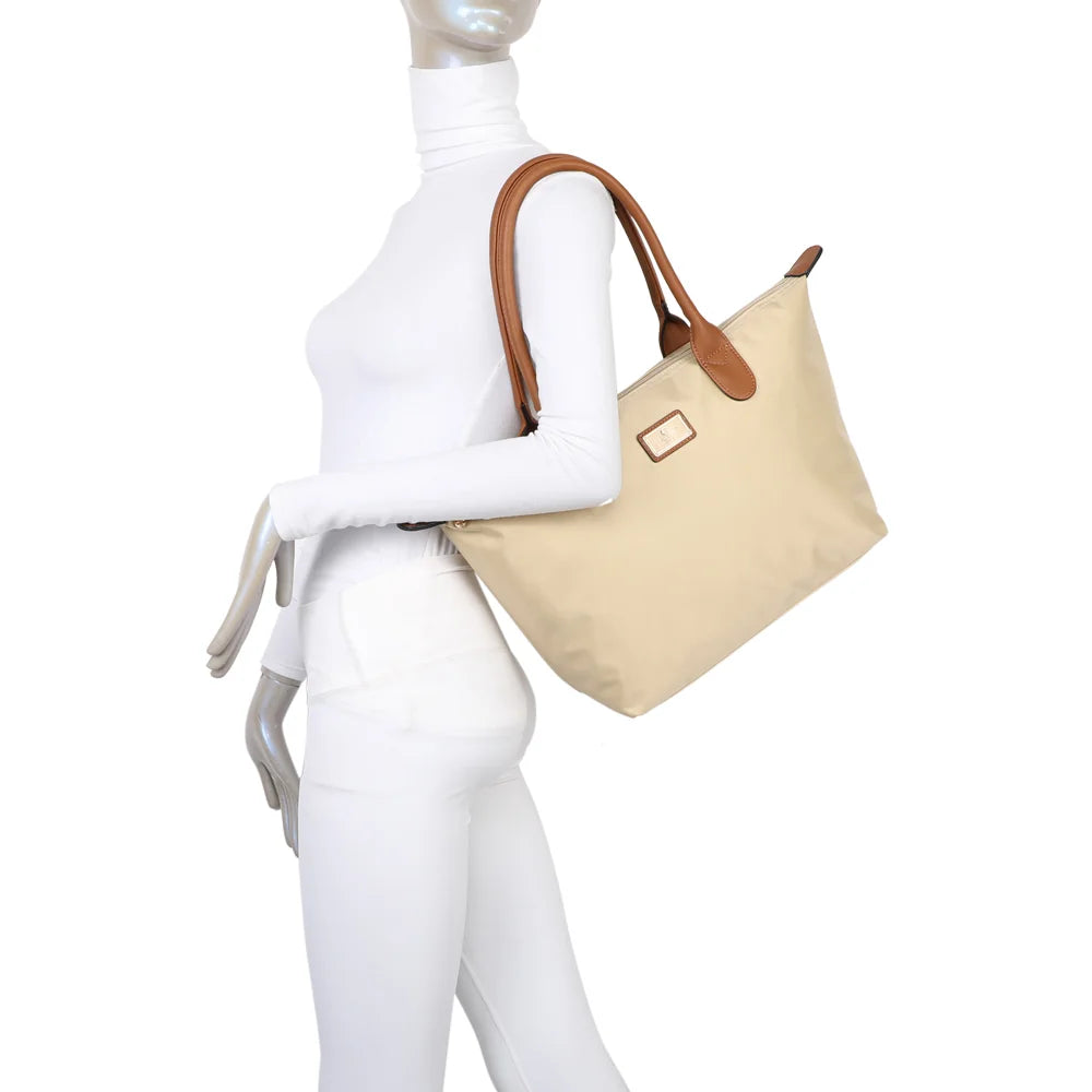 La Balade Medium beige portée par une femme : un sac cabas au format medium avec deux anses marron – réf. Z-03