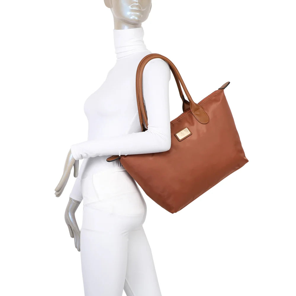 La Balade Medium camel portée par une femme : un sac cabas au format medium avec deux anses marron – réf. Z-03