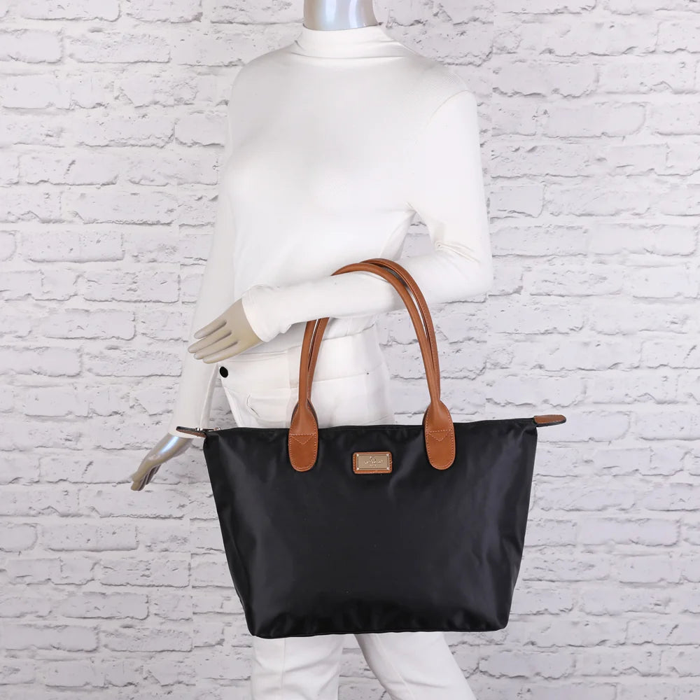 La Balade Medium noir portée par une femme : un sac cabas au format medium avec deux anses marron – réf. Z-03