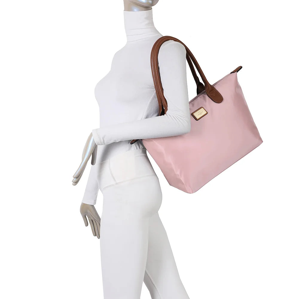 La Balade Medium rose claire portée par une femme : un sac cabas au format medium avec deux anses marron – réf. Z-03