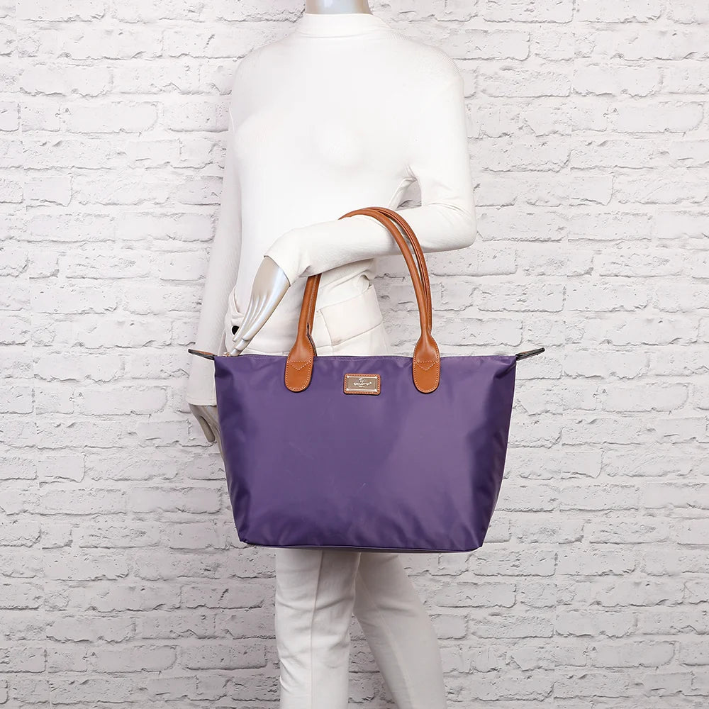 La Balade Medium violet portée par une femme : un sac cabas au format medium avec deux anses marron – réf. Z-03