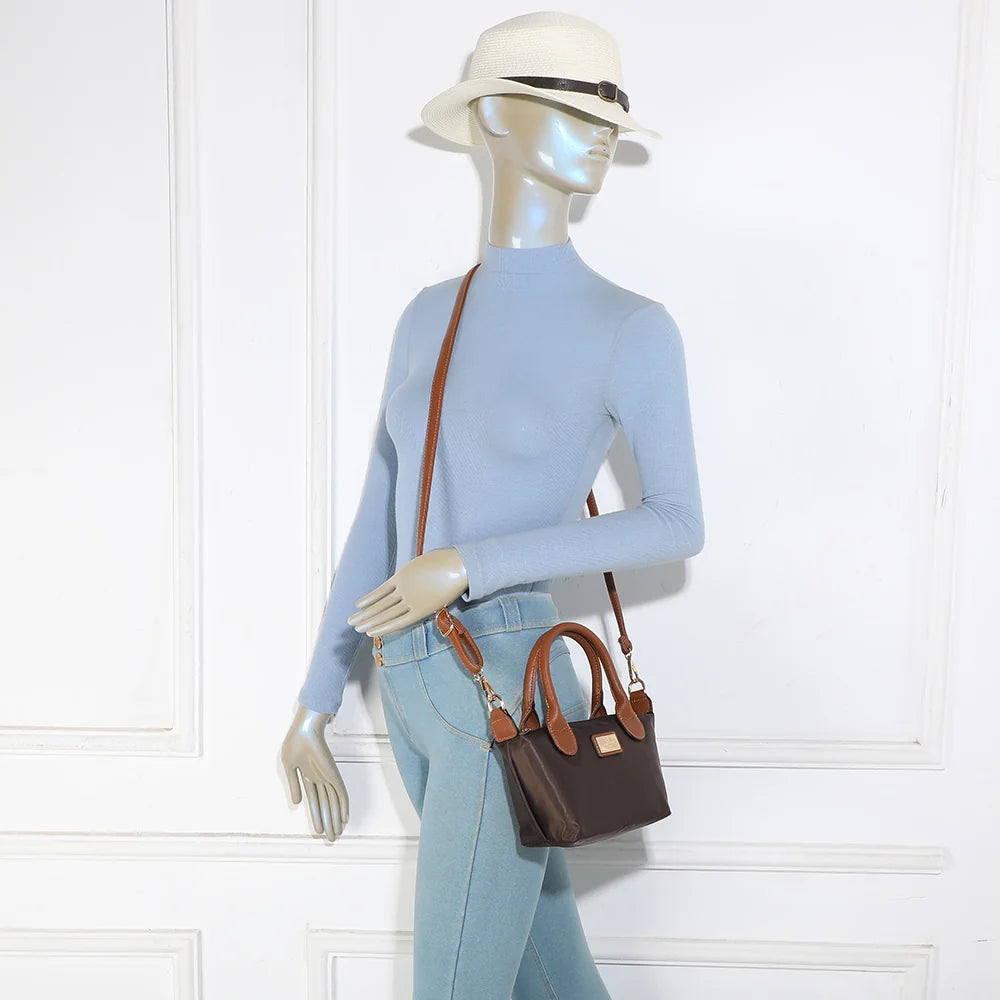 Mini sac La Balade (Mini) café porté par une femme, tenu à la main par ses anses courtes camel – réf. Z-05