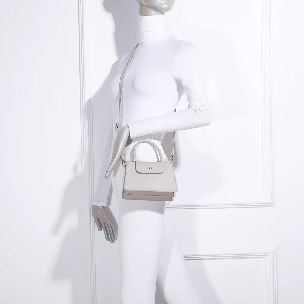 La Céleste beige portée par une femme, à la main par sa poignée ou avec la bandoulière ajustable – réf. R-1635