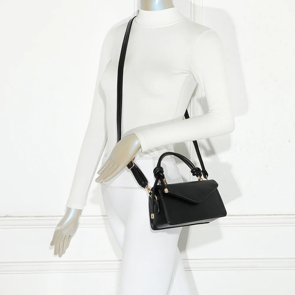 Sac La Céline noir porté par une femme, à la main par la poignée nouée ou à l’épaule avec la bandoulière – réf. C-0183