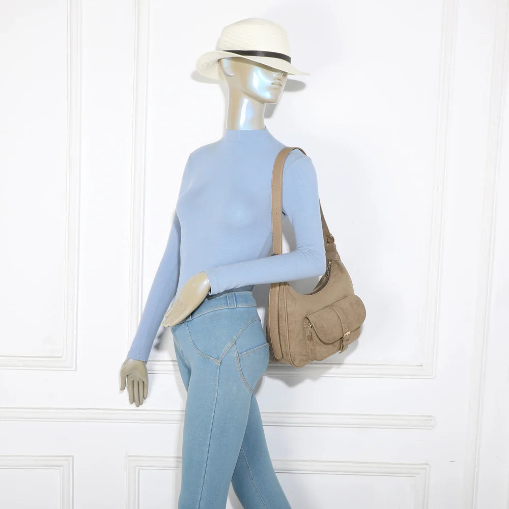 La Désirable taupe foncé porté à l’épaule par une femme, anse réglable de 38 cm de hauteur