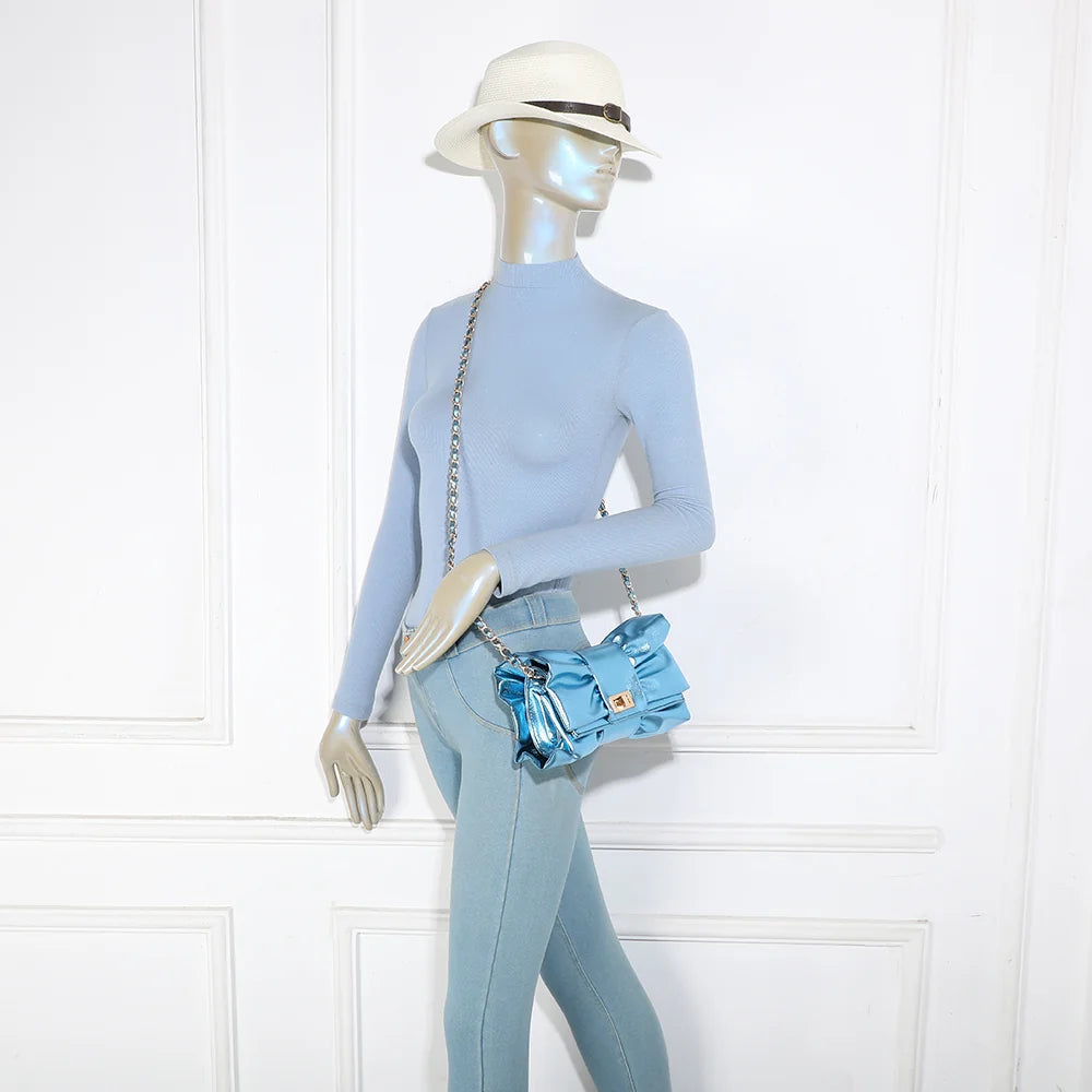 Pochette La Diva bleu portée par une femme : le nœud oversize illumine une tenue habillée – réf. DQ-37006