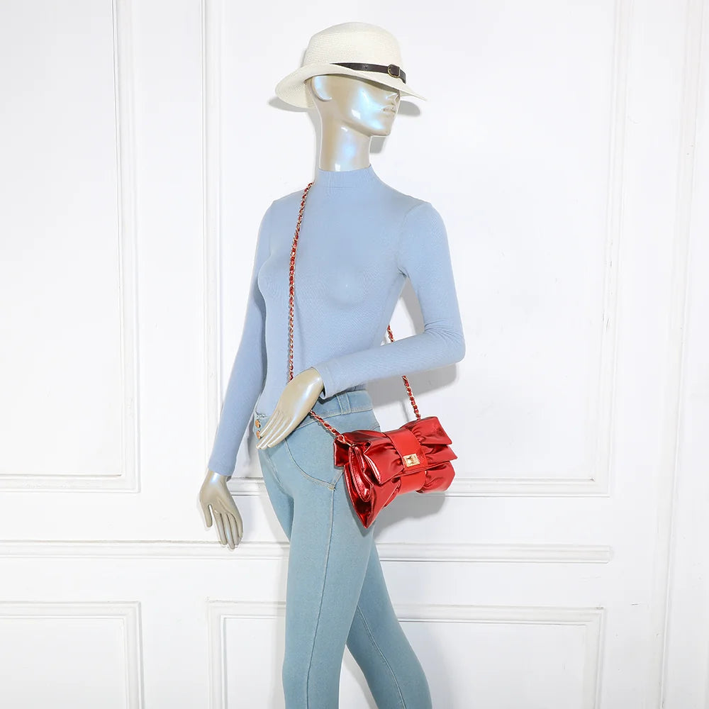 Pochette La Diva rouge portée par une femme : le nœud oversize illumine une tenue habillée – réf. DQ-37006