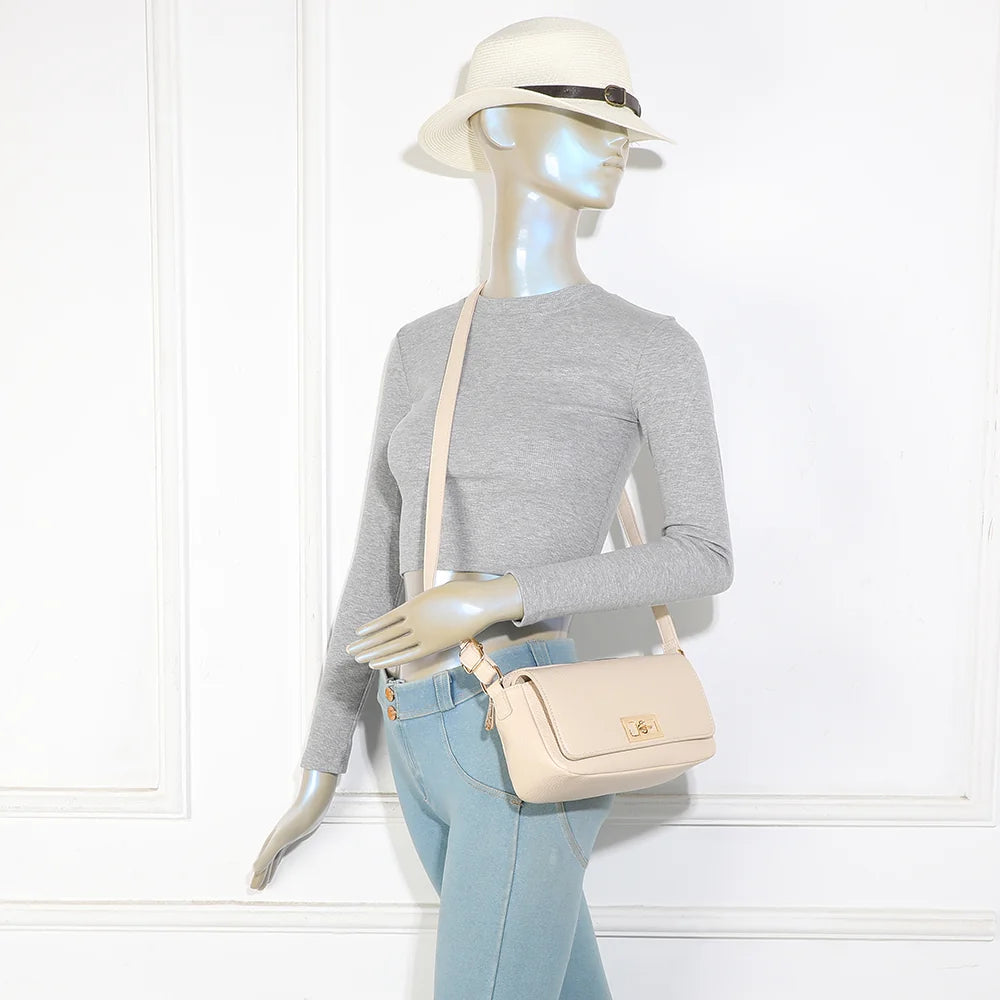 La Divine beige portée à l’épaule par une femme, anse réglable et fermoir tournant doré en évidence – réf. R-2050